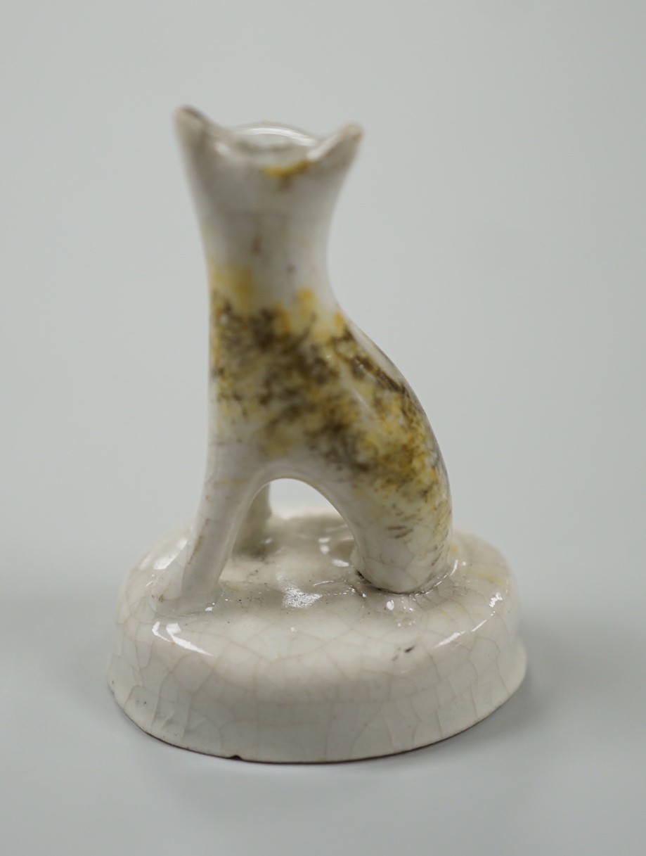 A seated toy Staffordshire model of a cat with tortoiseshell markings, c.1830-50. 4.5cm tall, Provenance: Dennis G.Rice collection